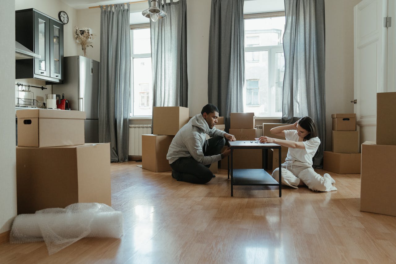 services-bg Young couple assembling furniture in their new apartment, surrounded by cardboard boxes.