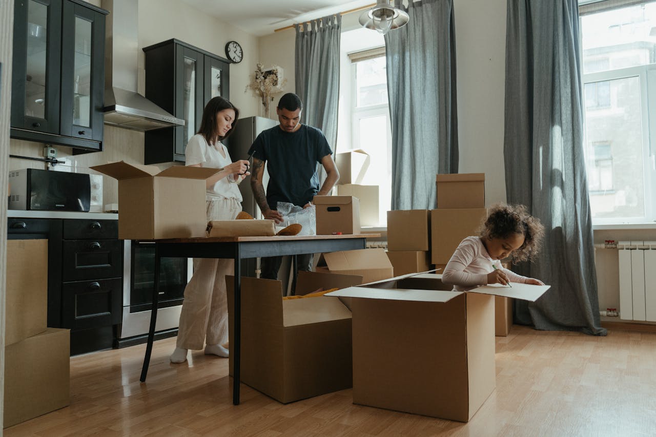 get-in-touch A family unpacking boxes in their new apartment kitchen. Relocation and new beginnings.