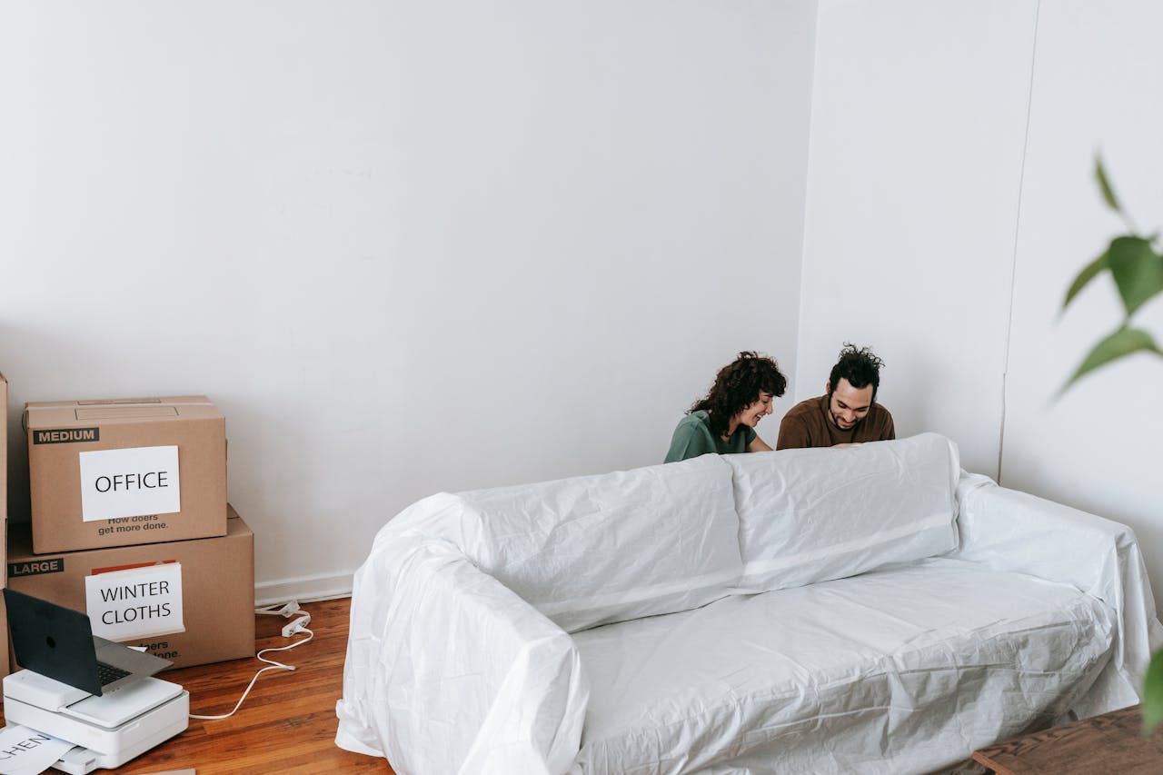 home-hero A couple enjoys moving into a new home, surrounded by boxes and minimalist decor.